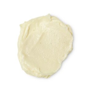A medium circular puddle of some pale yellow body wash, on a white background.