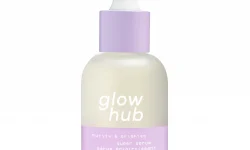 A tall cylindrical white glass bottle with a white rubber pipette lid and a pale lilac label that has Glow Hub Purify & Brighten Super Serum written in bold white writing on it, on a white background.