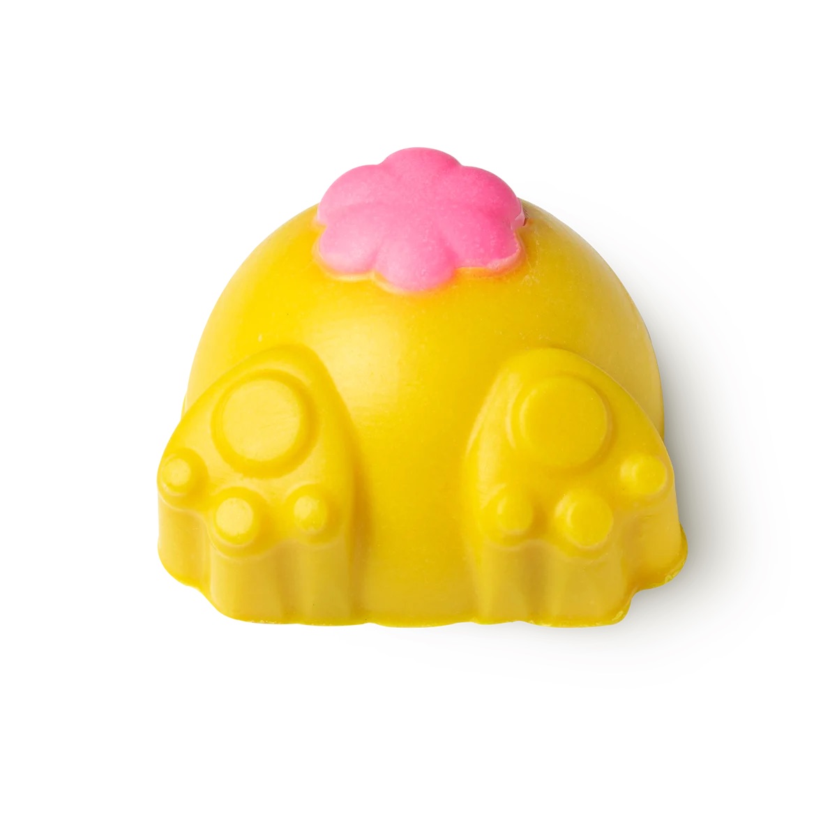A large bright yellow rabbit’s behind shaped block of solid body scrub that has two bright yellow paws coming out of the bottom of it and a bright pink fluffy tail engraved on it, on a white background.