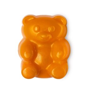 A medium bright orange teddy bear shaped block of Shower Jelly, on a white background.