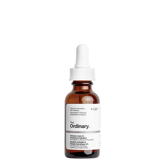 A short cylindrical brown glass bottle with a white rubber pipette lid and a white label that has The Ordinary Salicylic Acid 2% Anhydrous Solution written in bold black writing on it, on a white background.