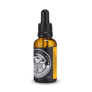 A short cylindrical brown glass bottle with a black rubber pipette lid and a white label that has Arthur J Hawke Sunset Boulevard Beard Oil written in bold white writing and a picture of a black and white hawk on it, on a white background.