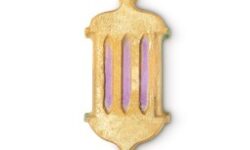 A large bright yellow lantern shaped bath bomb that has some specks of bright blue and pink all over it, on a white background.