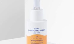 A short cylindrical white plastic bottle with a white rubber pipette lid that has By Beauty Bay SkinHit Correcting Serum with AHA and PHA written inn dark blue writing and a picture of a bright orange stripe on it, on a white background.