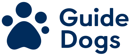 Shine The Spotlight | October 2022 | Guide Dogs Edition A picture of a large white dogs paw that has Guide Dogs written in bold white writing underneath it on a bright blue background.