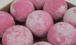 A large spherical shaped bright red Bath Bomb, on a white background.