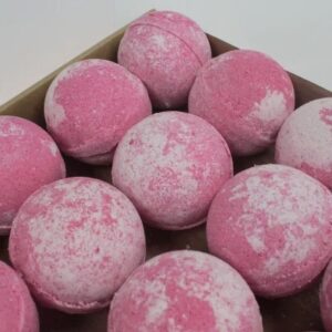 A large spherical shaped bright red Bath Bomb, on a white background.