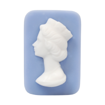 A large rectangular pale green block of soap that has a picture of a bright white woman wearing a crown engraved on it, on a white background.