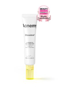 A tall thin conical White Plastic Tube with a bright yellow Lid that has Acnemy Zit Control® written in bold black writing on it, on a white background.