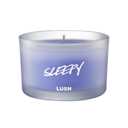 Filling My Home With A Luscious Scent | Lush Candle Range | Gifted A short cylindrical frosted glass jar full of some pale lilac wax, on a white background.
