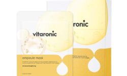 A tall rectangular white plastic pouch that has SNP Prep Vitaronic Ampoule Mask written in bold black writing, a picture of a bright yellow stripe, and a picture of a pale yellow bubble on it, on a white background.