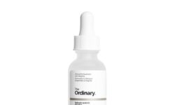 A short cylindrical clear glass Bottle with a white rubber pipette lid full of some bright white liquid with a white label that has the ordinary salicylic acid 2% solution written in bold black writing on it, on a white background.