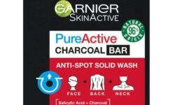 A large rectangular bar of soap wrapped in some black paper that has Garnier written in bold white writing, Pure Active Anti-Spot and Blackhead Solid Wash Charcoal Bar written in bold black writing, and a picture of a Red box on it, on a white background.