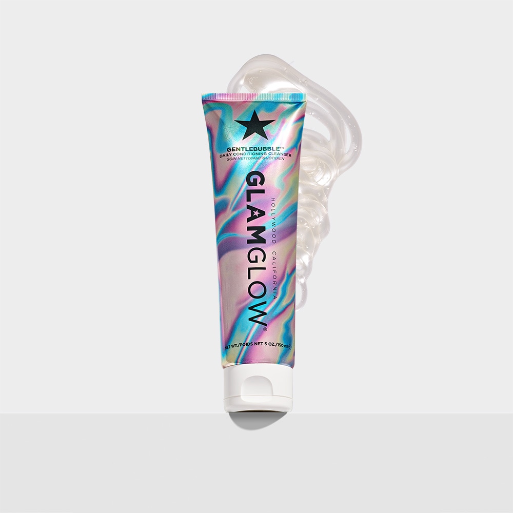 Cleansing My Skin With So Many Different Kinds Of Bubbles | GlamGlow GentleBubble™ Daily Conditioning Cleanser A tall conical metallic rainbow effect blue, Pink and purple plastic tube with a white plastic lid that has GlamGlow GentleBubble™ Daily Conditioning Cleanser written in bold black writing and a picture of a black star on it, on a white background.