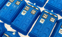 A large rectangular dark blue time machine shaped bath bomb that has some bright white windows and police box written in bold white writing engraved on it, on a white background.