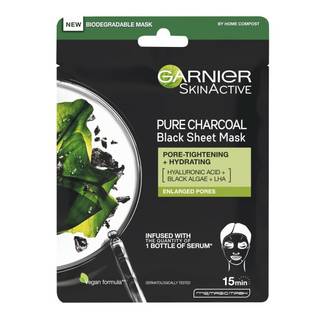 A tall rectangular black plastic pouch that has Garnier SkinActive Moisture Bomb Charcoal & Algae Hydrating Sheet Mask written in bright white writing and a picture of some dark green leaves on it, on a white background.