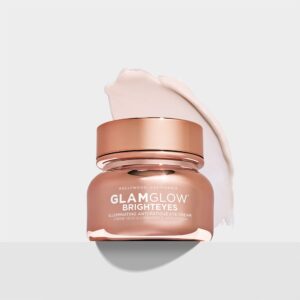 A short cylindrical clear plastic tub full of some bright gold liquid with a bright gold plastic lid that has GlamGlow BrightEyes Illuminating Anti-Fatigue Eye Cream written in bold white writing and a picture of a white star on it, on a white background.