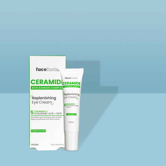 A long and thin conical white plastic tube with a white plastic lid and a white label that has Face Facts Ceramide Replenishing Eye Cream written in bold black writing on it next to a tall rectangular white cardboard box that has Face Facts Ceramide Replenishing Eye Cream written in bold black writing on it, on a white background.