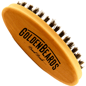 A small oval light wooden beard brush with some black bristles that has Golden Beards engraved on top of it, on a white background.