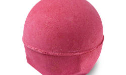 A large dark red rounded hexagonal shaped bath bomb that has some gold lustre all over it, on a white background.