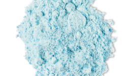 A pile of some bright blue powder that has some pieces of Fine Sea Salt running through it, on a white background.