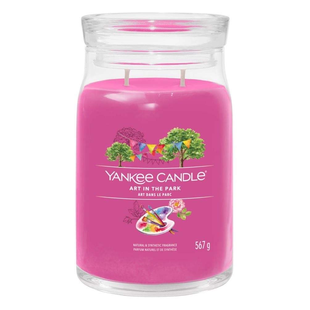 Going For A Nice Walk In The Park | Yankee Candle Art In The Park Collection A tall cylindrical glass jar full of some bright pink wax with a label that has Yankee Candle written in white writing, Art In The Park written in black writing, and a picture of an art easel next to some bright green trees covered in some bright white bunting on it, on a white background..