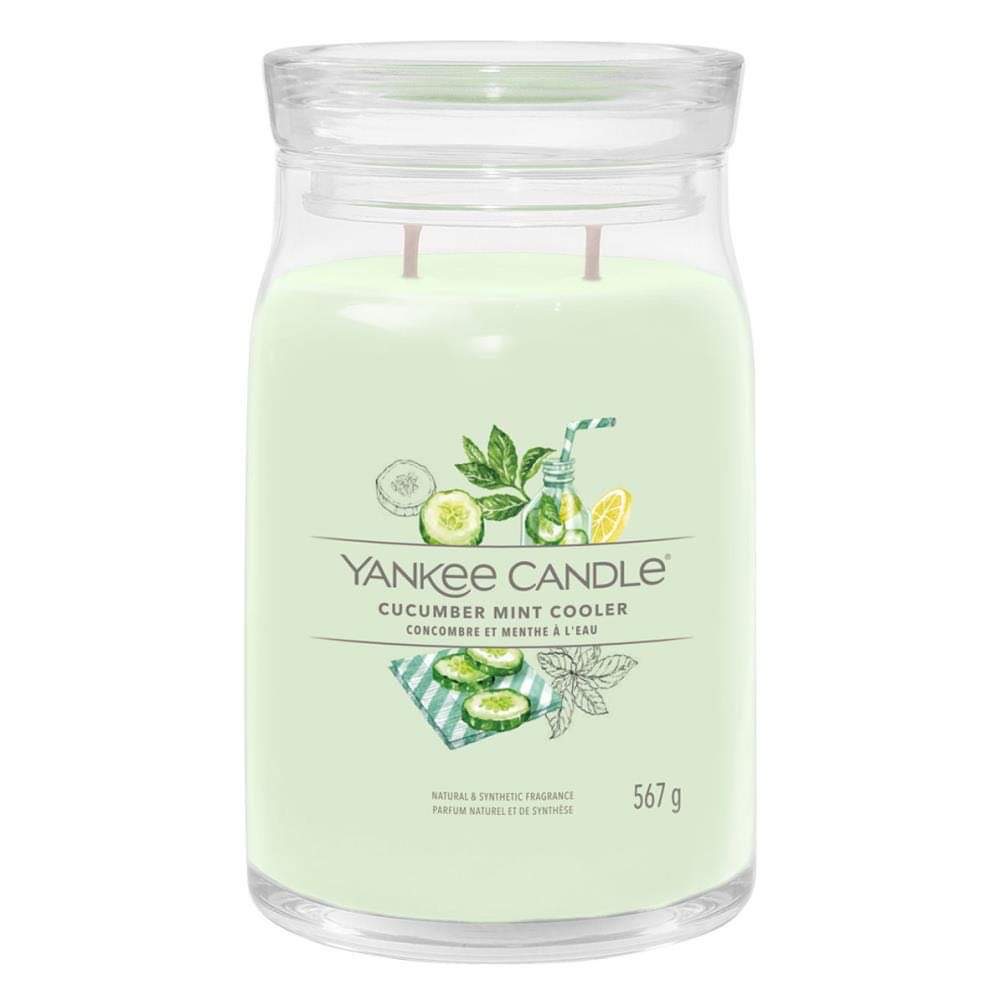 What I Thought of the Yankee Candle Advent House 2014 A tall cylindrical glass jar full of some light green wax with a label that has Yankee Candle written in white writing, Cucumber Mint Cooler written in black writing, and some pictures of some bright green cucumbers and some dark green mint leaves on it, on a white background..