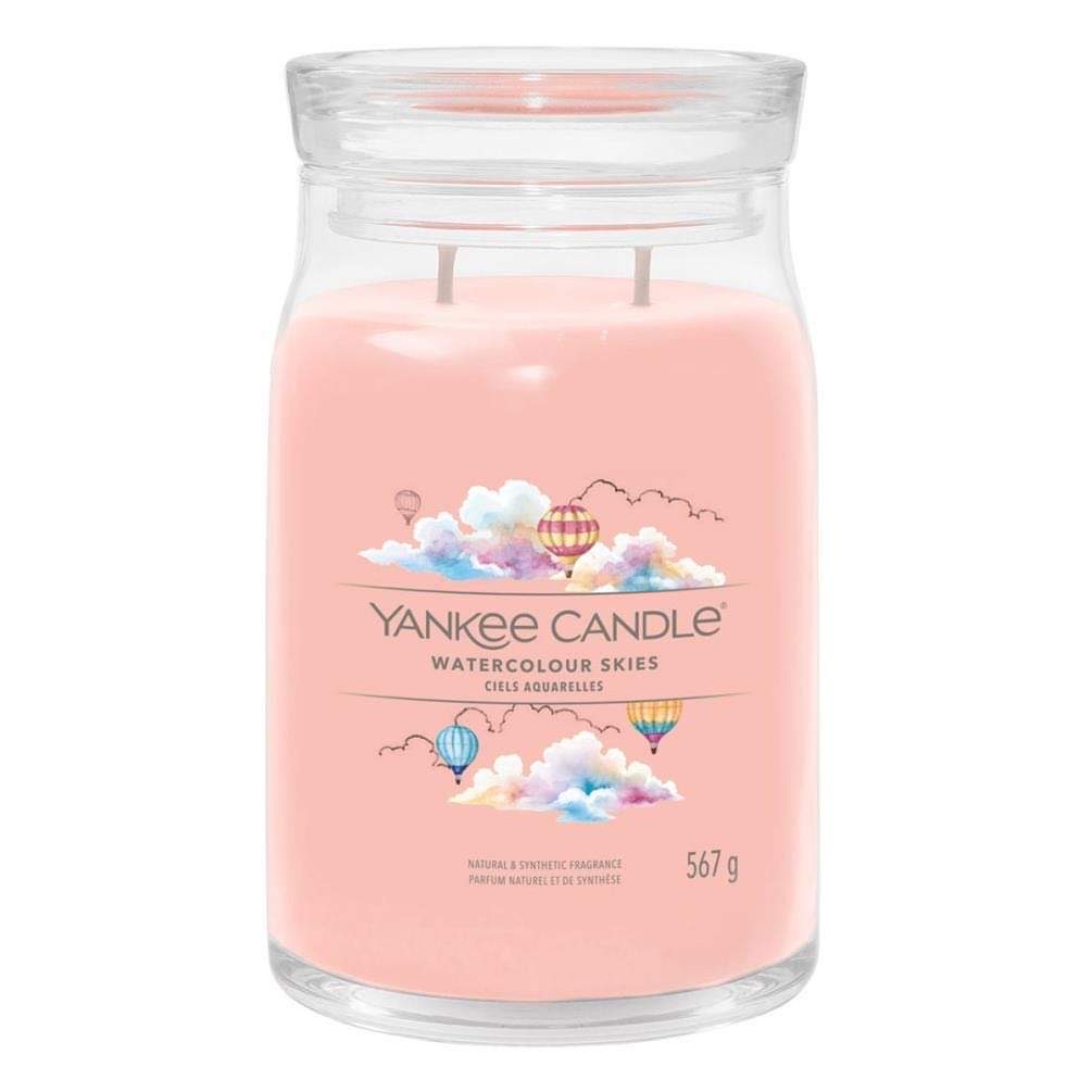 What I Thought of the Yankee Candle Advent House 2014 A tall cylindrical glass jar full of some pale pink wax with a label that has Yankee Candle written in white writing, Watercolour Skies written in black writing, and some pictures of some multicoloured Hot Air Balloons surrounded by some multicoloured pastel clouds on it, on a white background..