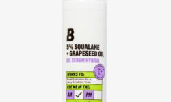 A short cylindrical white plastic Bottle with a clear plastic lid and a white label that has By Beauty Bay written in bold black writing and 5% Squalane + Grapeseed Oil Serum Hybrid written in dark purple writing on it, on a white background.