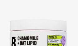 A short cylindrical white plastic tub with a white label that has By Beauty Bay written in bold black writing, Chamomile + Oat Lipid Cleansing Balm written in dark purple writing, and a picture of a black letter B on it, on a white background.
