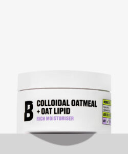 A short cylindrical white plastic tub with a white plastic lid that has By Beauty Bay Colloidal Oatmeal + Oat Lipid written in bold black writing and Rich Moisturiser written in dark purple writing on it, on a white background.
