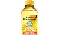 A tall rectangular bright yellow plastic bottle with a bright yellow plastic lid that has Garnier written in bright green writing and Ultimate Blends Hair Drink Nourishing Banana Liquid Conditioner written in bright white writing on it, on a white background.