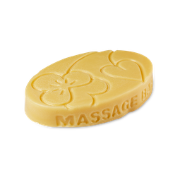 A medium golden yellow oval shaped block of solid massage oil that has some pictures of some Violet Flowers engraved on it, on a white background.