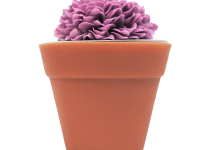 A short cylindrical dark terracotta flower pot shaped block of soap that has some dark purple flowers coming out of the top of it, on a white background.