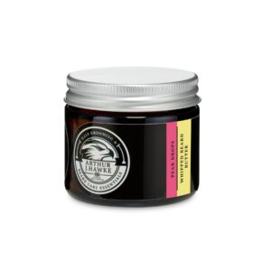 A short cylindrical black glass jar with a silver metallic lid and a gradient black and white label that has Arthur J Hawke Pear Drops Beard Butter written in bold white writing and a picture of a black hawk on it, on a white background.