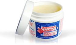 A short cylindrical clear plastic tub full of some creamy white liquid with a light blue label that has Egyptian Magic All Purpose Skin Cream written in bright red writing on it, on a white background.