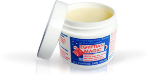 A short cylindrical clear plastic tub full of some creamy white liquid with a light blue label that has Egyptian Magic All Purpose Skin Cream written in bright red writing on it, on a white background.