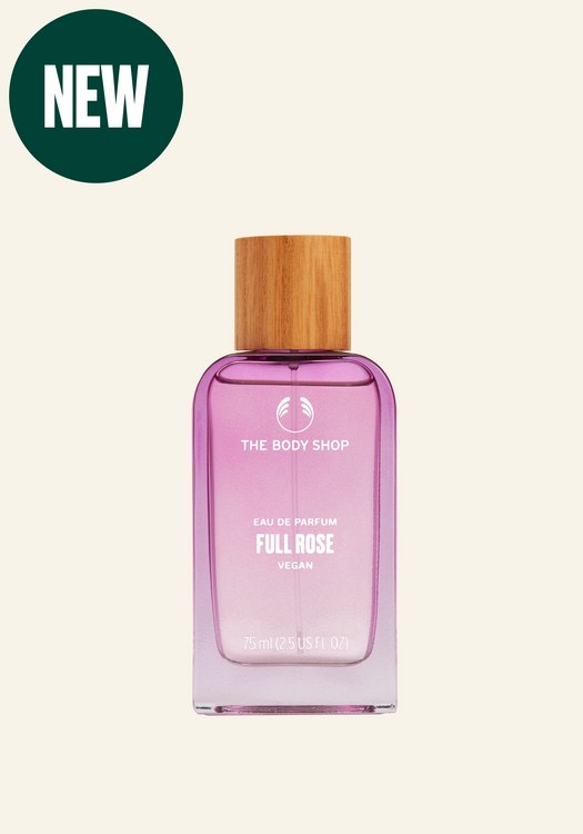 I Can Buy Myself A Whole Bunch Of Flowers | The Body Shop Full Flowers Collection A tall rectangular clear glass bottle full of some translucent peach liquid with a light wooden Lid that has The Body Shop Full Rose Eau De Parfum written in bold white writing on it, on a white background.