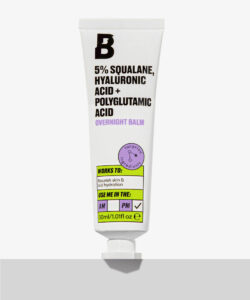 A short cylindrical white plastic tube with a metallic white lid that has By Beauty Bay written in bold black writing and 5% Squalane, Hyaluronic Acid + Polyglutamic Acid Overnight Balm written in dark purple writing on it, on a white background.