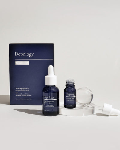 A short cylindrical translucent blue Glass bottle with a white rubber pipette lid that has Depology Matrixyl 3000 Collagen Boosting Serum written in bright white writing on it next to a miniature translucent blue glass bottle with a white rubber pipette lid that has Depology Matrixyl 3000 Collagen Boosting Serum written in bright white writing on it and a medium rectangular light blue cardboard box that has Depology Matrixyl 3000 Collagen Boosting Serum Travel Set written in bright white writing on it, on a white background.