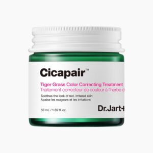 A short cylindrical clear Glass Jar full of some dark green liquid with a white metallic lid and a white label that has Dr. Jart+ written in bold black writing and Cicapair™ Tiger Grass Colour Correcting Treatment written in bright pink writing on it, on a white background.