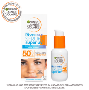 A short cylindrical bright white Glass Bottle with a metallic white pump lid that has Garnier written in bold black writing, Ambre Solaire Super UV Daily Invisible Face Serum written in dark blue writing, and SPF 50+ written in bright orange writing on it, on a white background.