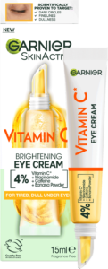A long and thin conical gradient bright white and yellow plastic tube with a white plastic lid that has Garnier SkinActive Brightening Eye Cream written in bold black writing and Vitamin C written in bright orange writing on it, on a white background.