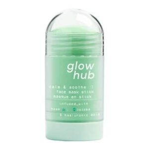 A tall cylindrical clear plastic twist up tube full of some pale green liquid with a light green dial and a bright green label that has Glow Hub Calm & Soothe Face Mask Stick written in bright white writing on it, on a white background.
