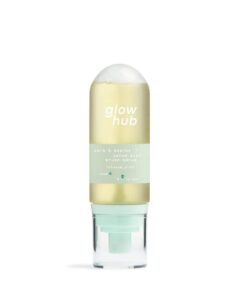 A tall cylindrical dome shaped clear plastic bottle full of some creamy white liquid with a clear plastic lid and a bright green label that has Glow Hub Calm & Soothe Serum Mist written in bright white writing on it, on a white background.