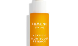 A short cylindrical bright orange glass Bottle with a white Rubber Pipette Lid and a bright orange label that has Lumene Nordic-C [Valo] Glow Boost Essence written in bright white writing on it, on a white background.