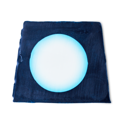 A medium dark blue square shaped block of soap that has a bright white circular moon engraved on it, on a white background.