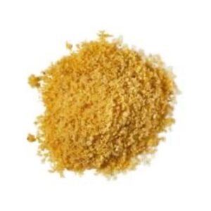 A medium circular puddle of some golden yellow showder that has some pieces of some Fine Sea Salt and Sand running through it, on a white background.