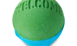 A medium spherical shaped bright green and blue bath bomb that has Welcome engraved on the top of it, on a white background.
