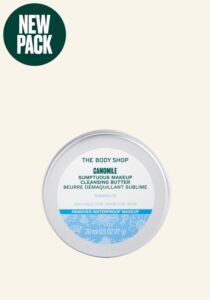 A short cylindrical silver Metal Tin with a gradient bright blue and white label that has The Body Shop Chamomile Sumptuous Makeup Cleansing Butter written in dark green writing on it, on a white background.